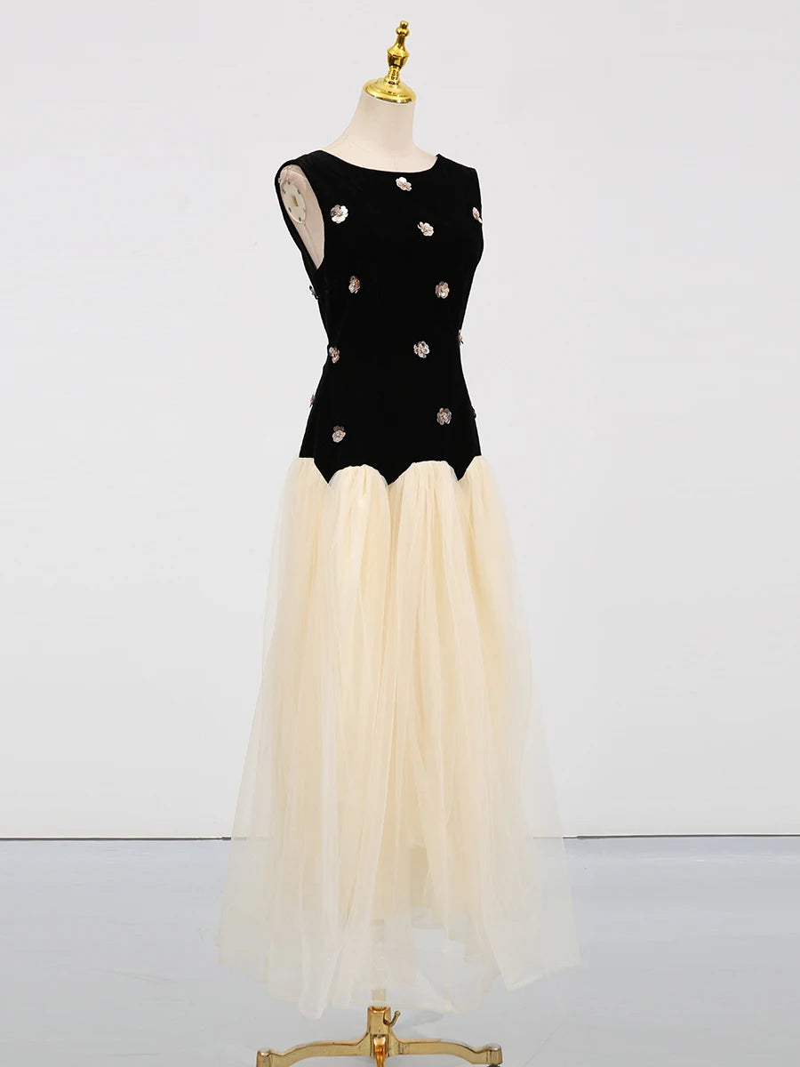 Black top with floral embellishments and beige skirt on a mannequin against a white background