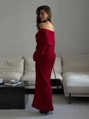 Woman in a red off-shoulder dress standing in a modern living room.