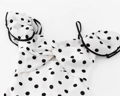 Close-up of the ruched bodice and ruffled sleeves of a polka dot dress