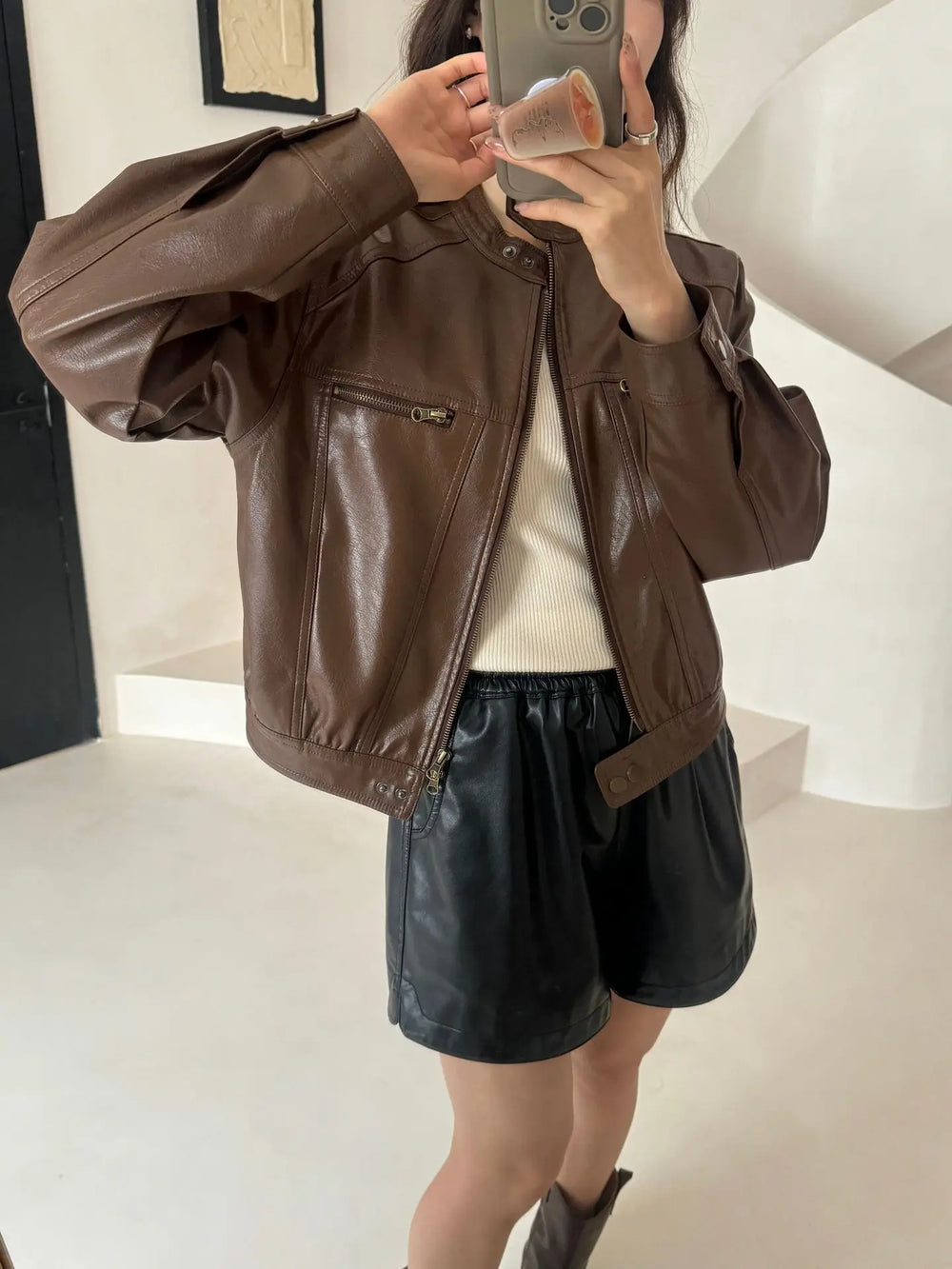 Brown faux leather moto jacket with black shorts