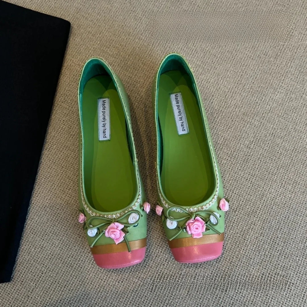 Green square toe flats with pink and gold accents and floral embellishments.