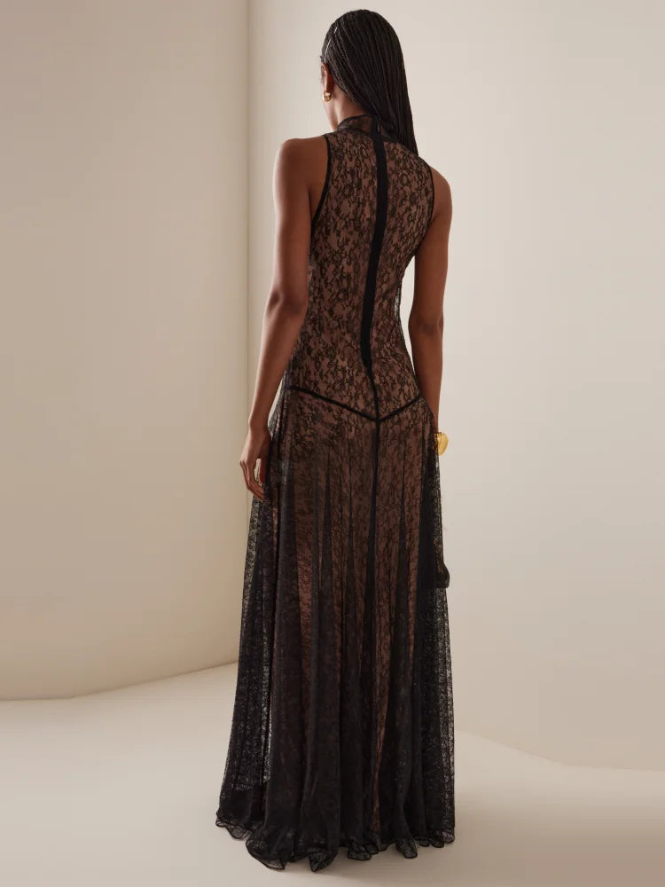 Woman wearing a black lace dress against a plain background