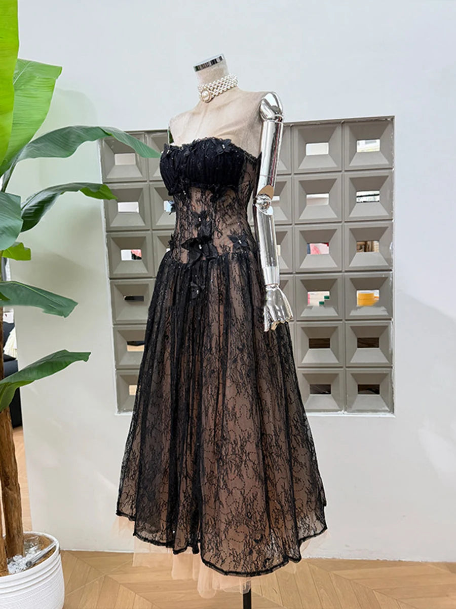 Black lace dress on a mannequin against a geometric wall pattern