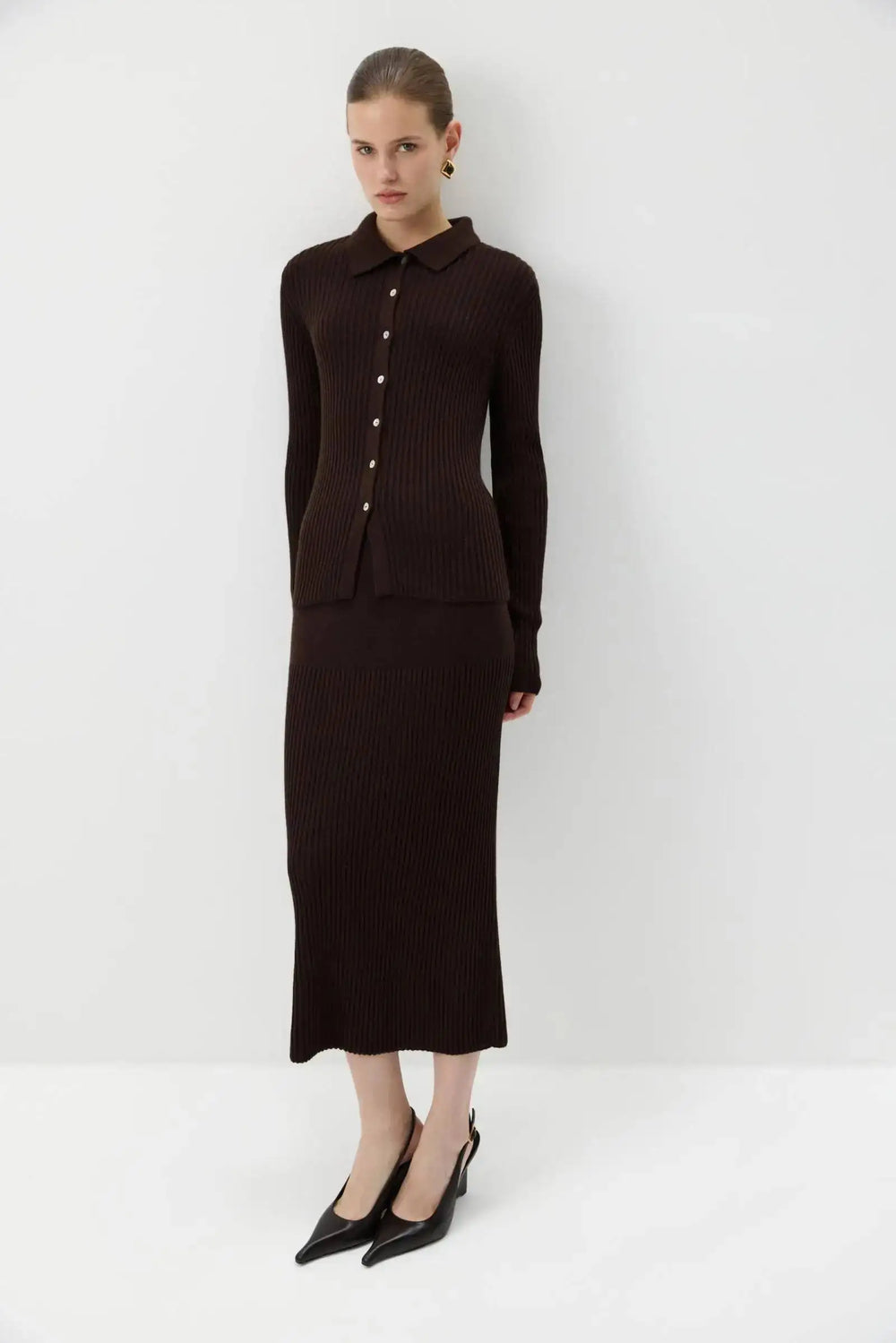 Model posing in brown ribbed knit polo top and midi skirt