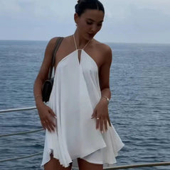 Woman in a white dress standing on a boat with ocean in the background
