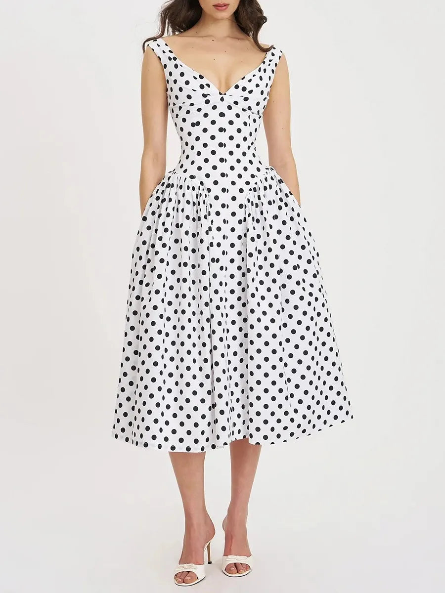 Flowing polka dot midi dress displayed with elegant V-neck silhouette.