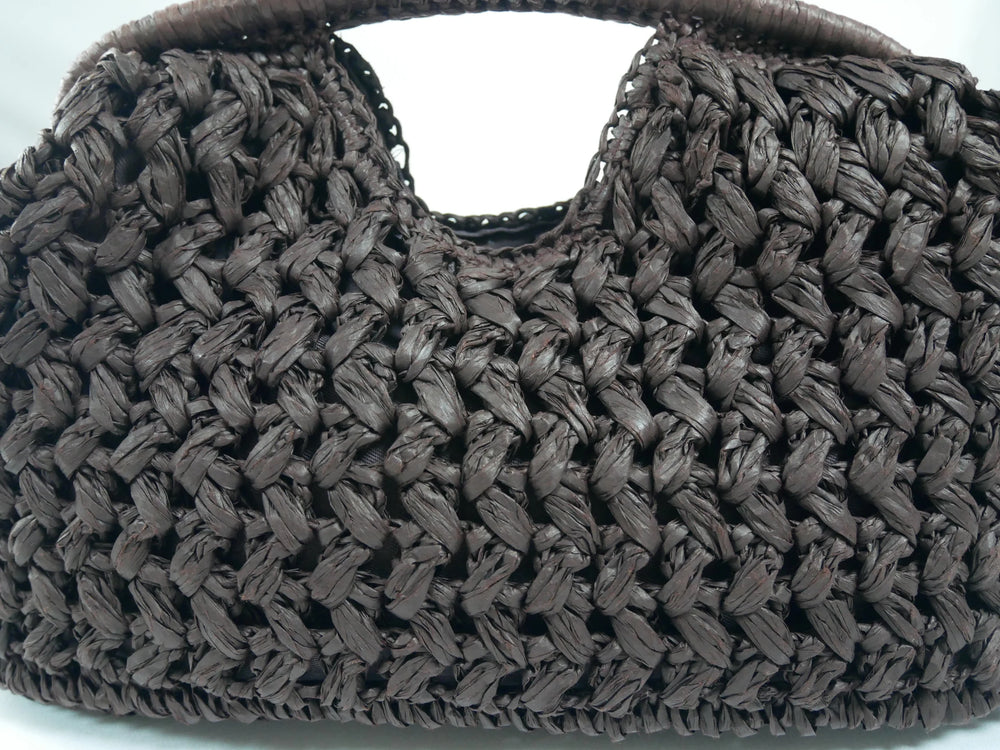 Close-up of a woven brown handbag on a white background