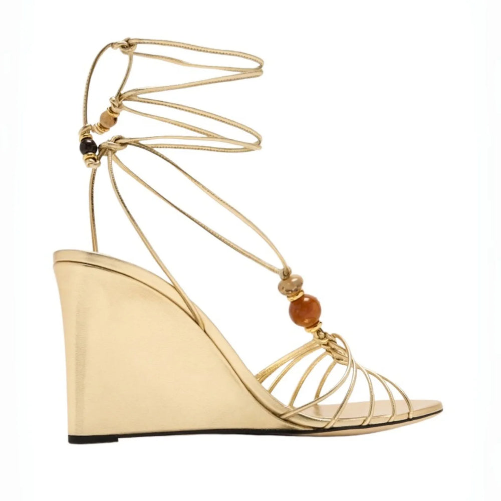Side view of gold strappy wedge sandals with natural stone beads