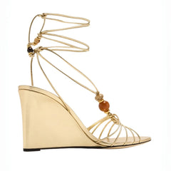 Side view of gold strappy wedge sandals with natural stone beads
