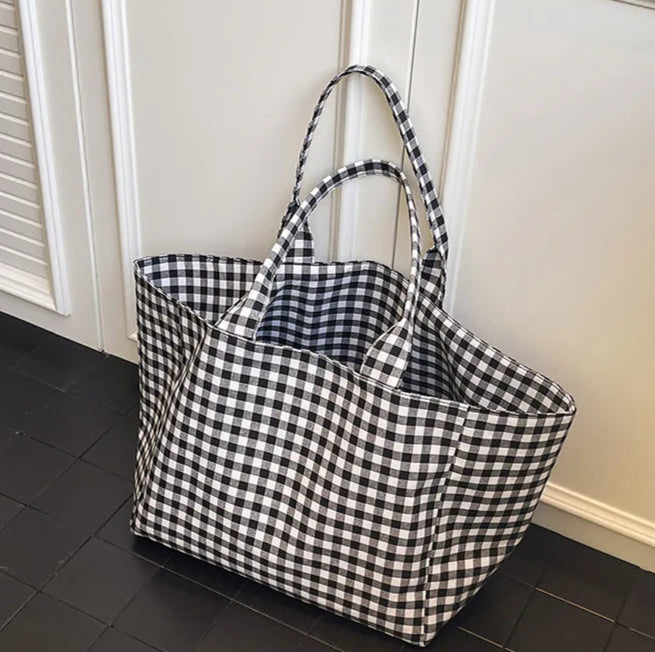 Black and white checkered tote bag on a tiled floor