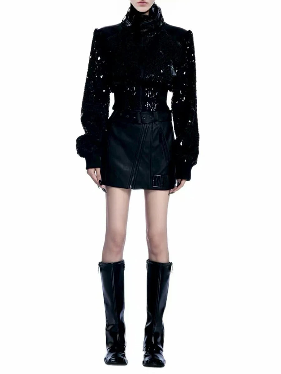Person wearing a black sequin jacket, black leather skirt, and black rain boots 