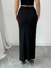Person wearing a black outfit with wide-leg pants against a neutral background