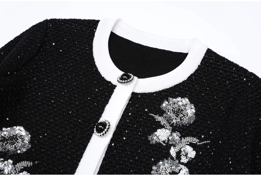 Close-up of the neckline and button detail on a black sequined knit cardigan.