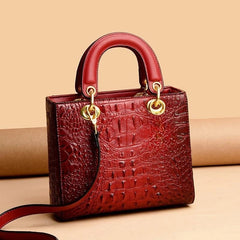  Close-up of the crocodile pattern texture on a top handle handbag, highlighting the luxurious detailing and craftsmanship. Wine Red 3