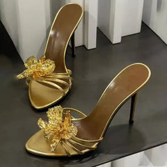 Gold stiletto heels with ornate floral embellishment