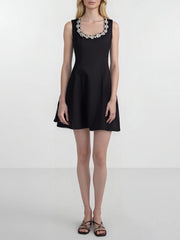 Black dress with decorative neckline on a white background