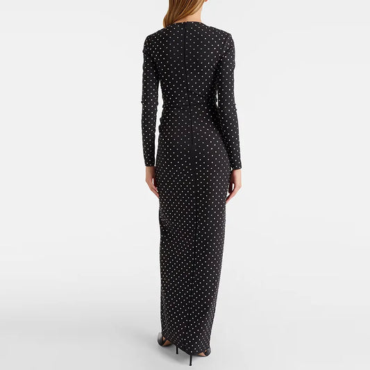 Back view of a woman wearing a black beaded polka dot maxi dress.