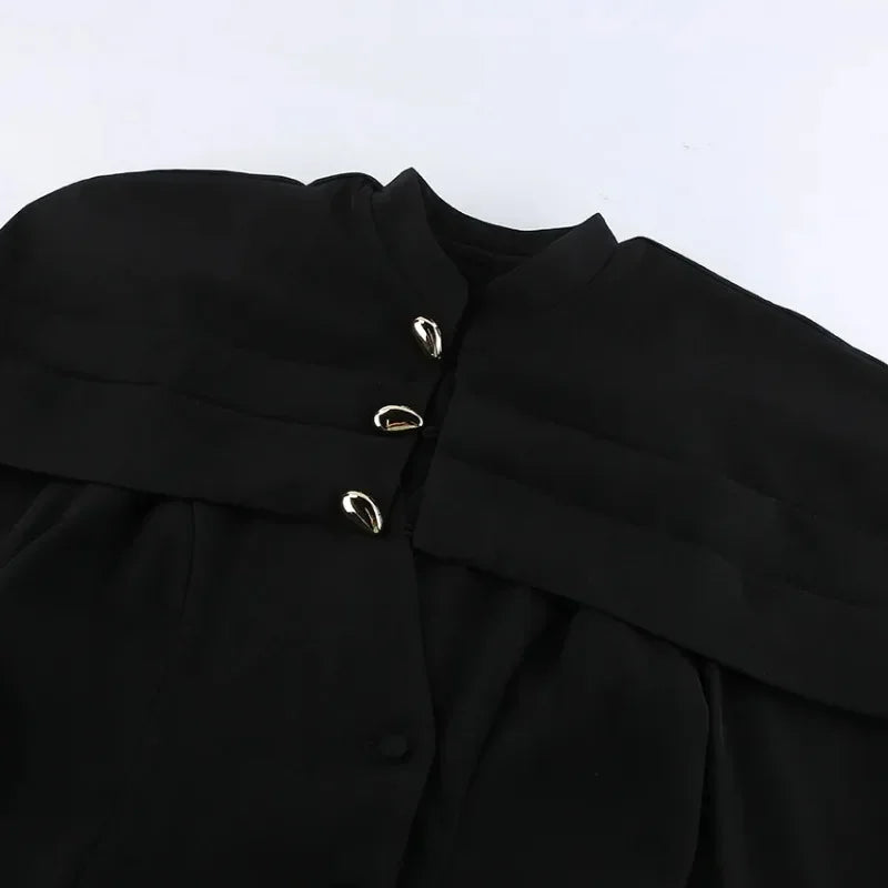 Close-up of a black garment with silver buttons on a white background