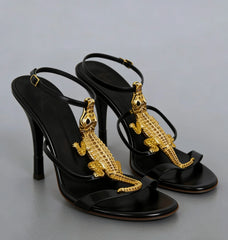 Black patent leather high heel sandals with gold alligator embellishments
