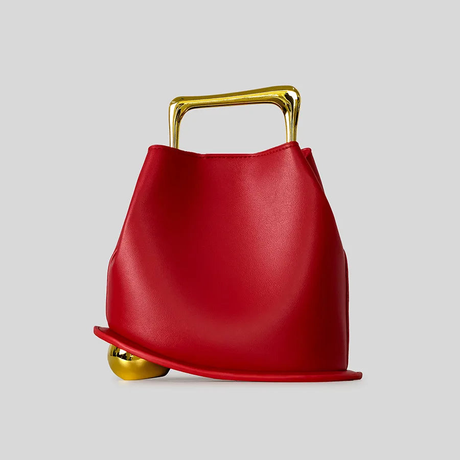 Red handbag with gold handle and base on a light gray background