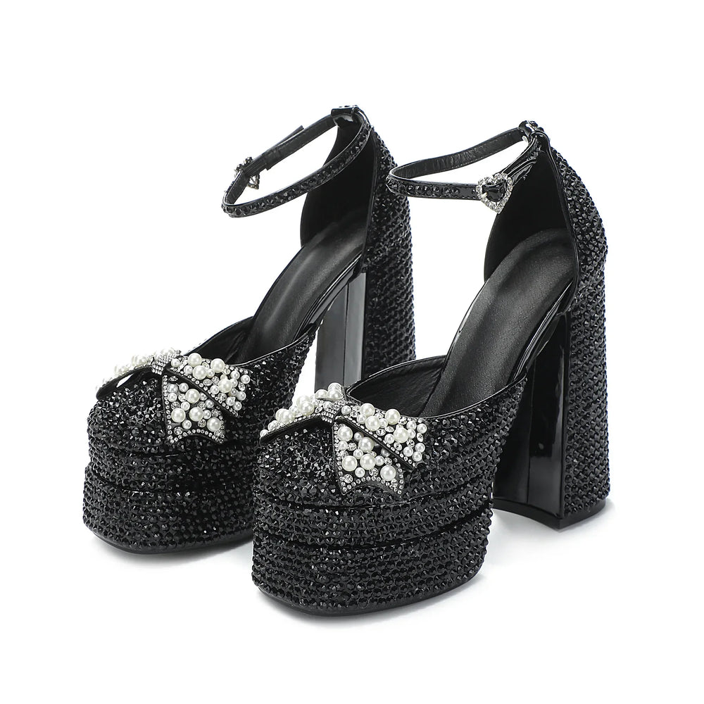 Black high-heeled shoes with crystal embellishments on a white background
