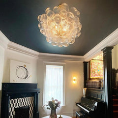 A stunning glass bubble chandelier hanging in a modern living room, creating a captivating focal point. Golden Atelier 2