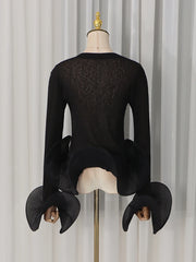 Back view of the black sheer knit top with pleated flare sleeves