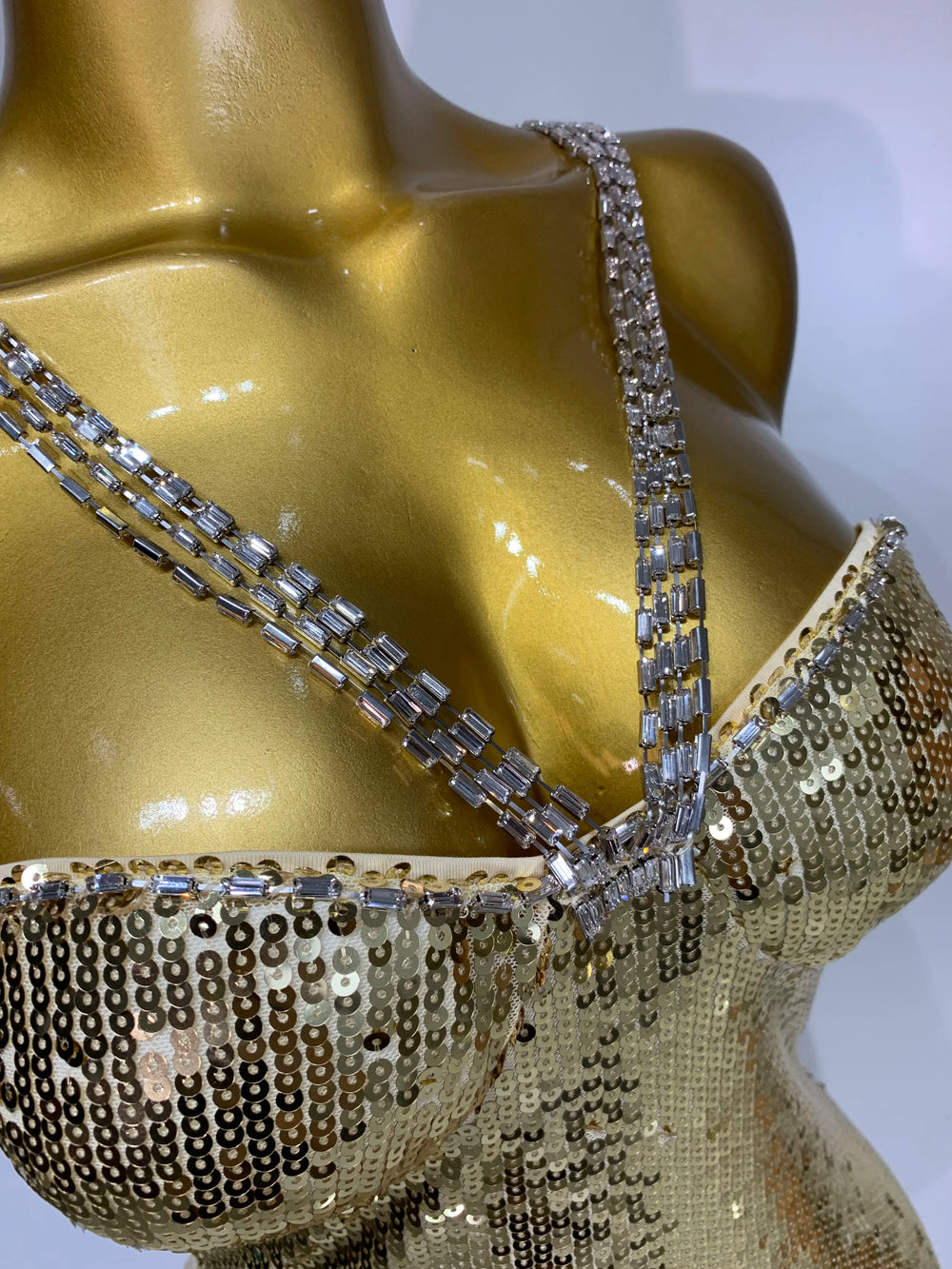 Close-up of gold sequin detailing and spaghetti straps on a maxi dress.