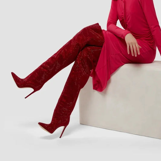 Red crystal embellished over the knee boots worn with a red dress.
