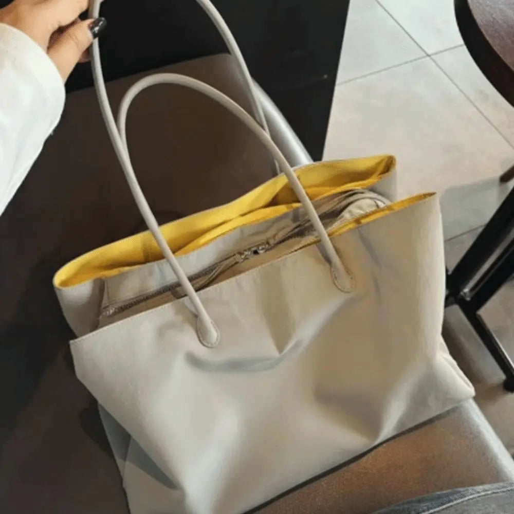 Grey tote bag with yellow lining, open showing interior