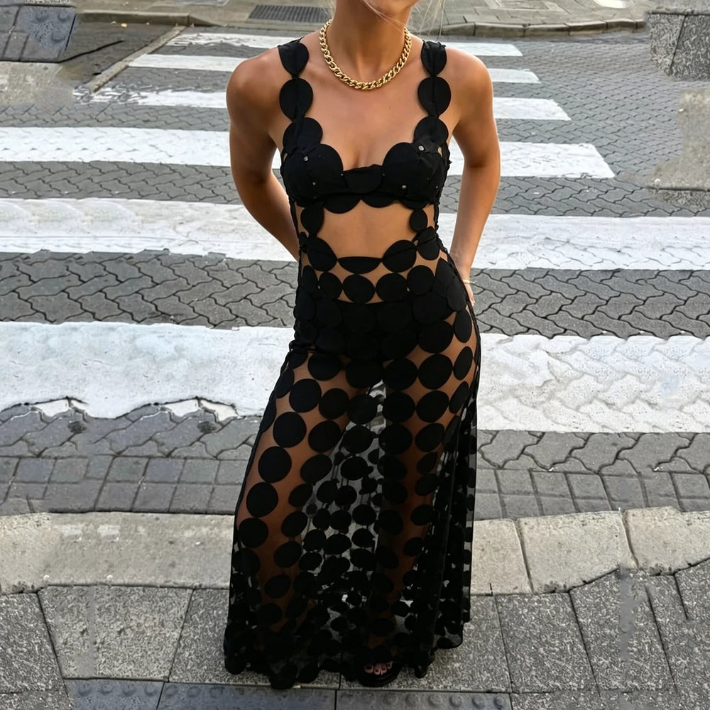 Black cut out dot mesh maxi dress worn on a crosswalk with gold necklace