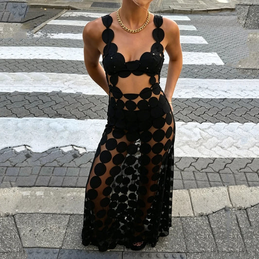 Black cut out dot mesh maxi dress worn on a crosswalk with gold necklace
