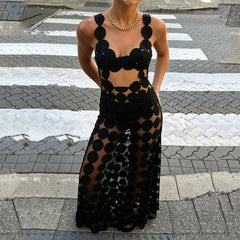 Black cut out dot mesh maxi dress worn on a crosswalk with gold necklace