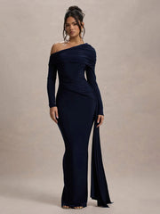 Woman wearing a navy one-shoulder gown against a beige background