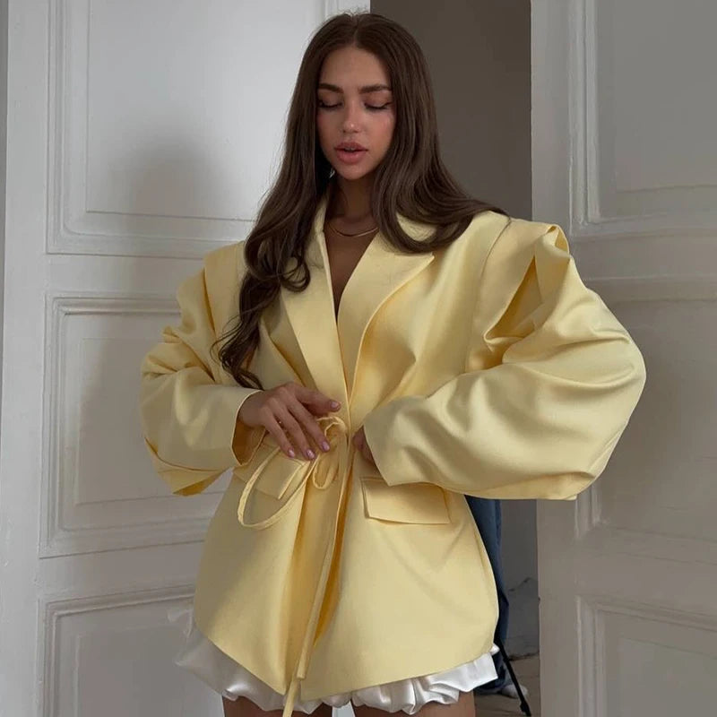 Woman wearing a yellow robe standing in a doorway.