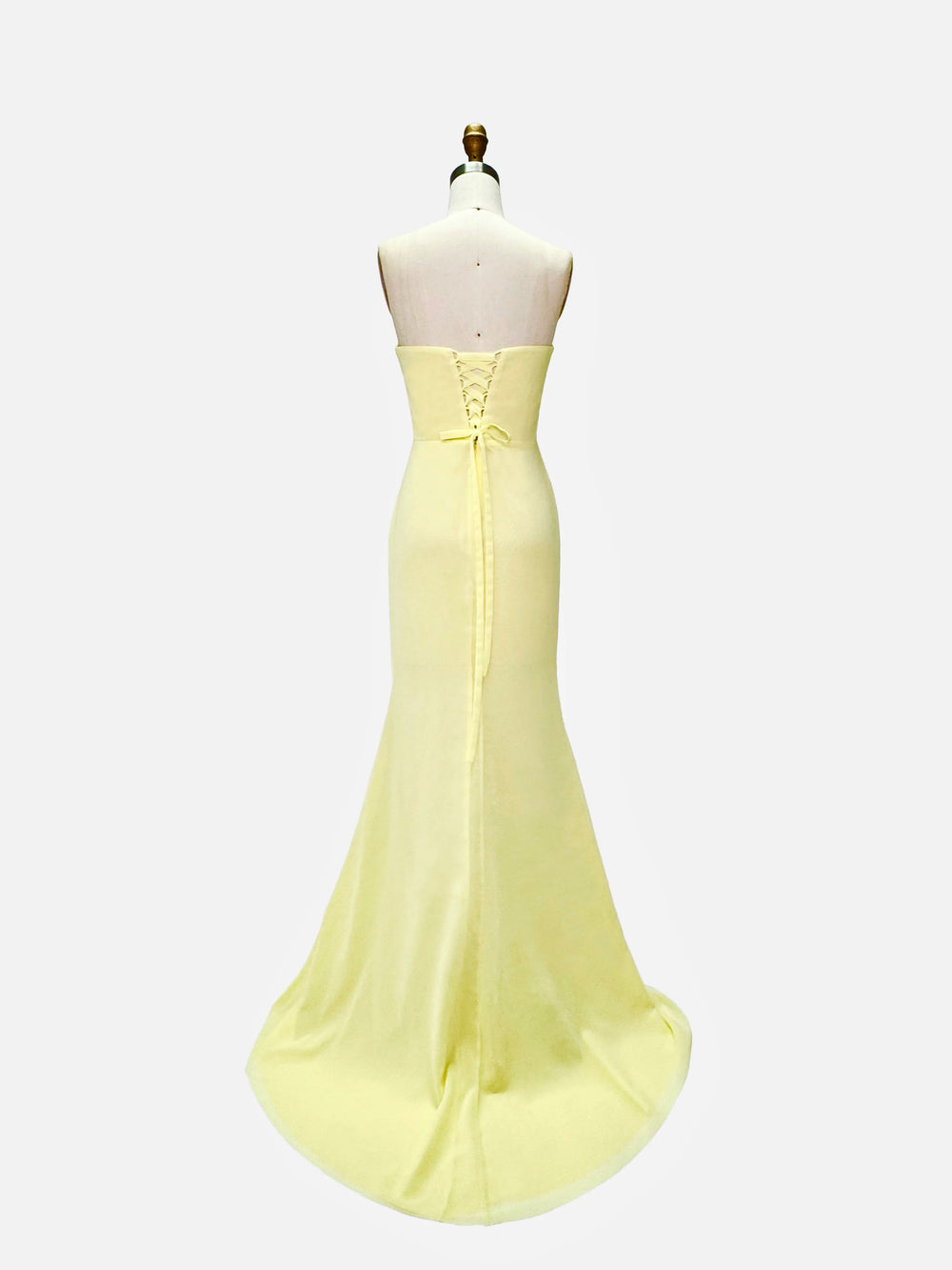 Yellow evening gown on a mannequin against a white background