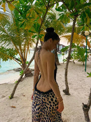 A model wearing a leopard print halter maxi dress with an open back, showcasing its glamorous style. Golden Atelier 3