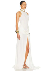 Woman wearing a white halter neck gown with a slit on a white background