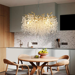 A sparkling crystal branch chandelier illuminating a modern dining room. 1