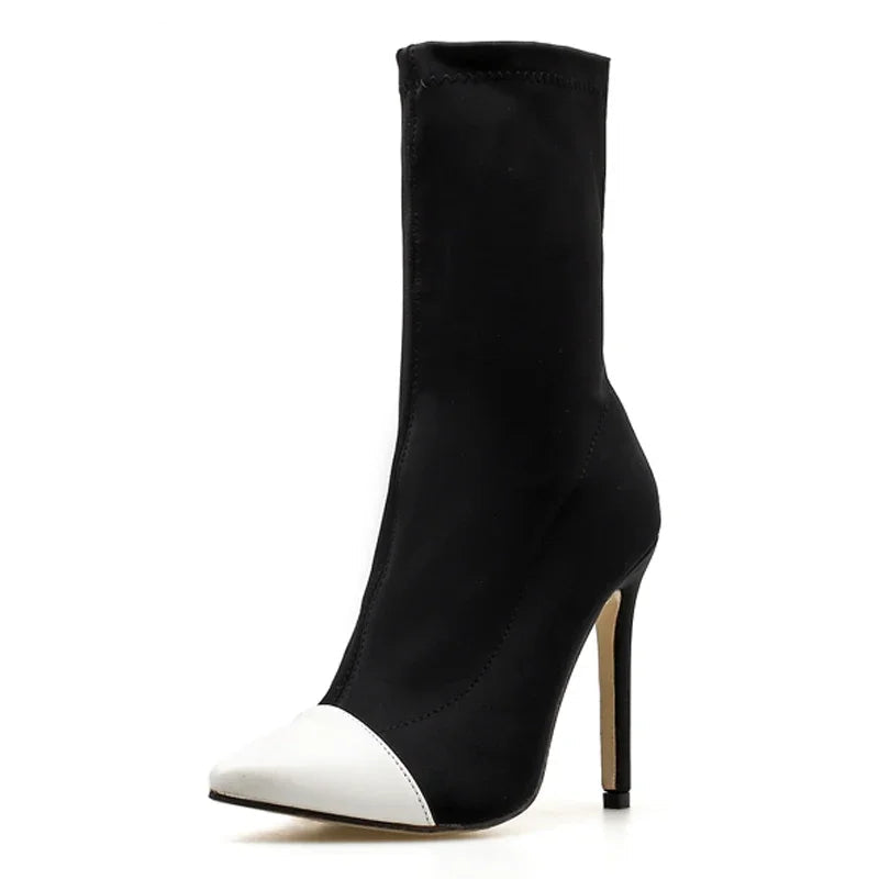 Black high-heeled ankle boot with white pointed toe on a white background