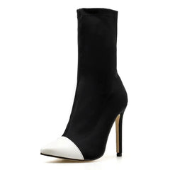 Black high-heeled ankle boot with white pointed toe on a white background