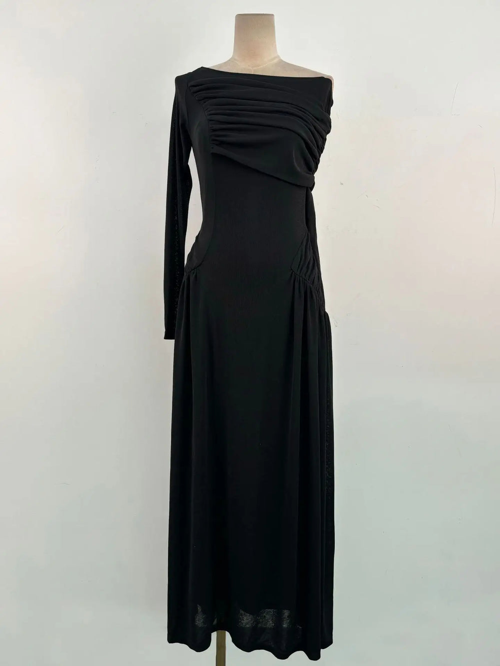 Black off-shoulder dress on a mannequin against a white background