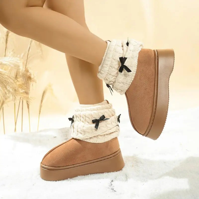 Brown winter boots with white ribbed cuffs and black bows on a light background