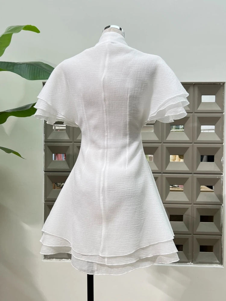 White dress on a mannequin against a light gray background with geometric pattern