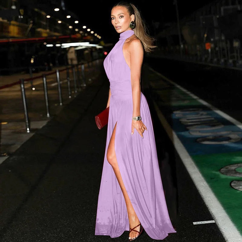 Woman in a purple dress standing on a track at night