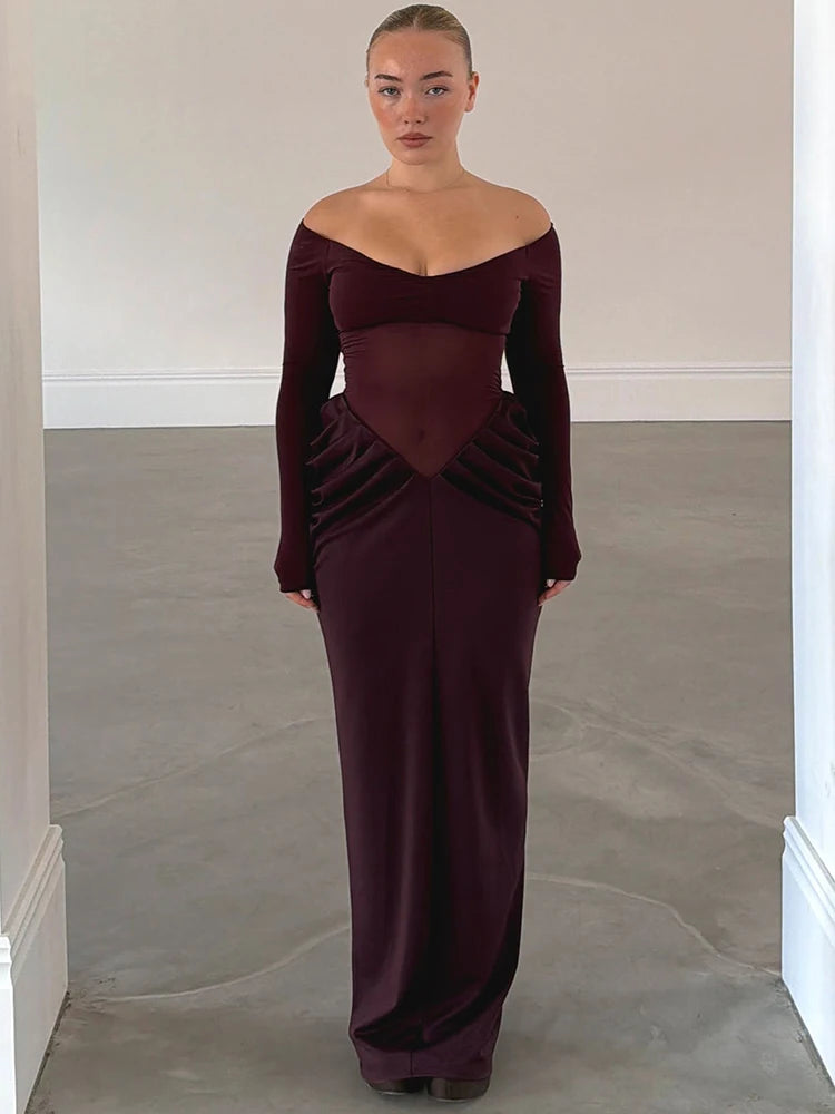 Model wearing an off shoulder long sleeve maxi dress with ruched waist detail in an interior setting.