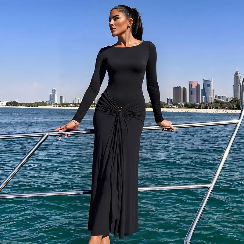 Woman in a black dress standing on a boat with a city skyline in the background