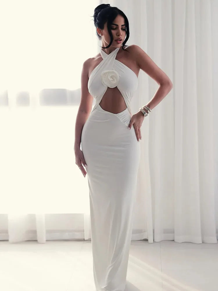 Woman wearing a white evening gown with a floral detail in a bright room.