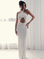 Woman wearing a white evening gown with a floral detail in a bright room.