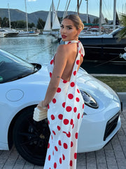 Back view of a polka dot halter neck maxi dress.
